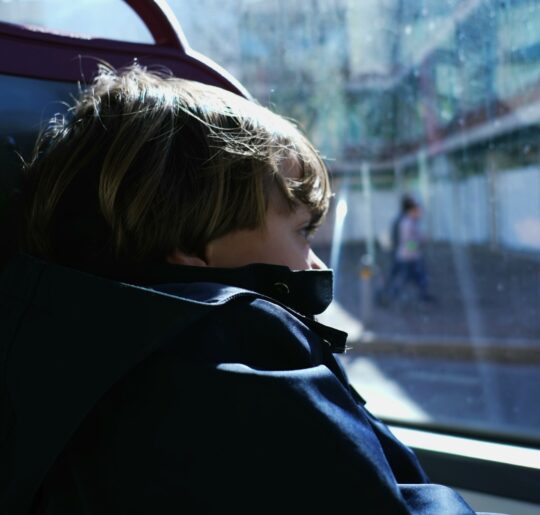 A child looking through the window of a moving vehicle