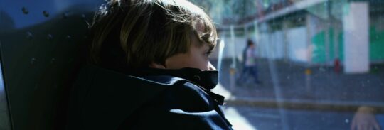 A child looking through the window of a moving vehicle