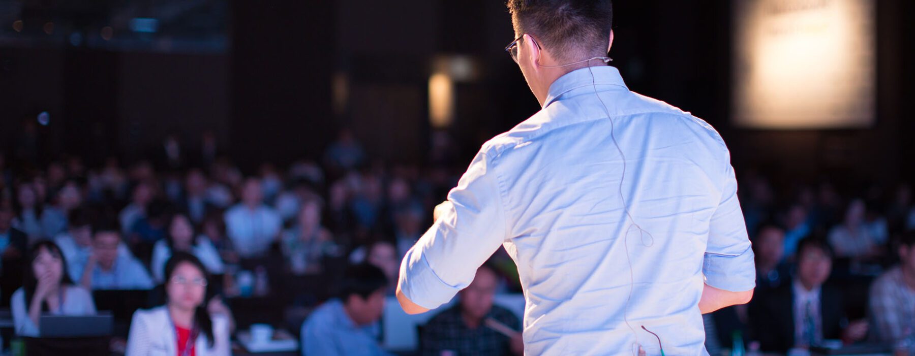 A man addressing a crowd from a stage