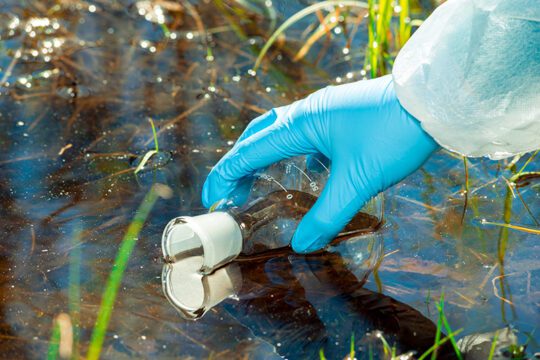 Taking a water sample from a river